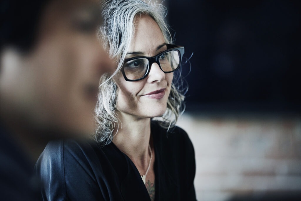 Smiling businesswoman listening during team meeting in office conference room